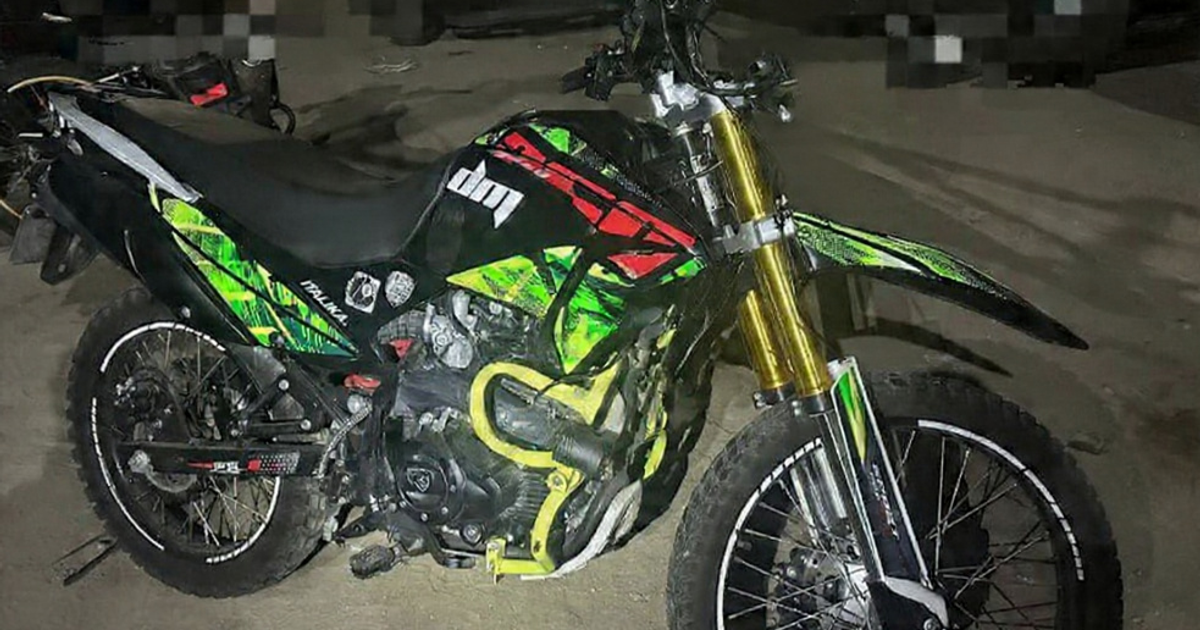 Motocicleta Italika colorida estacionada en una superficie de tierra, bajo iluminación tenue, fue recuperada en Mazatlán tras una denuncia anónima.