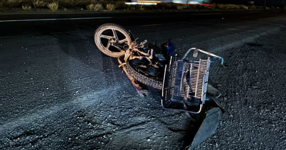 Imagen de una motocicleta volcada sobre una carretera oscura, relacionada con un accidente mortal en Los Mochis.