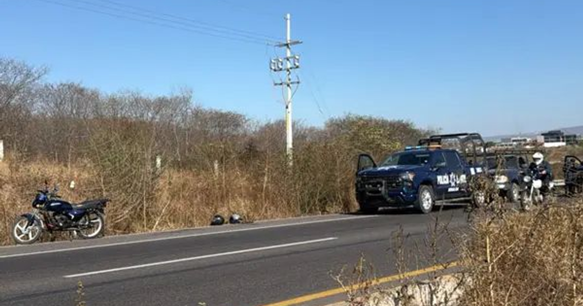 Motocicleta aparcada en carretera con policía presente tras incidente en Culiacán.