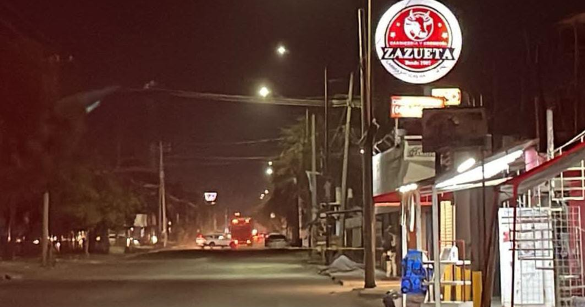 Calle nocturna con letrero iluminado 'Zazueta' en Culiacán, Sinaloa, México