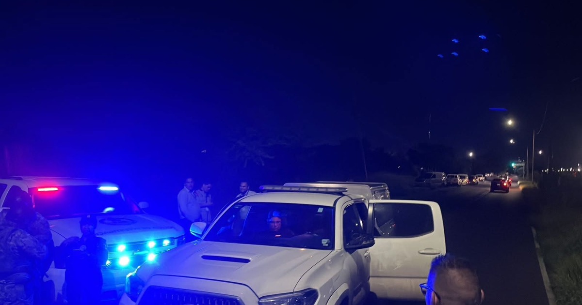 Escena urbana nocturna en Culiacán con vehículos y autoridades
