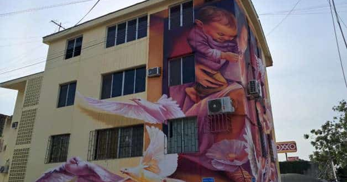 Mural 'Sembrando Paz' con un niño, palomas y flores, en un edificio con un letrero de OXXO al fondo en Culiacán.