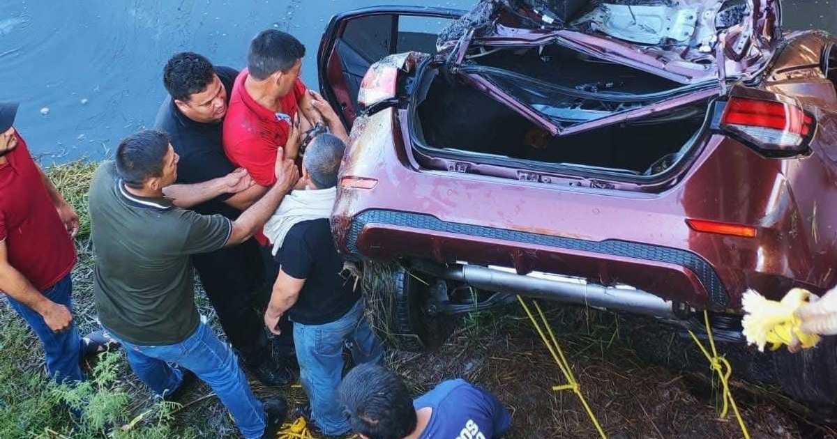 Personas ayudan en un accidente automovilístico cerca de un canal de Navolato, el 07 de noviembre.