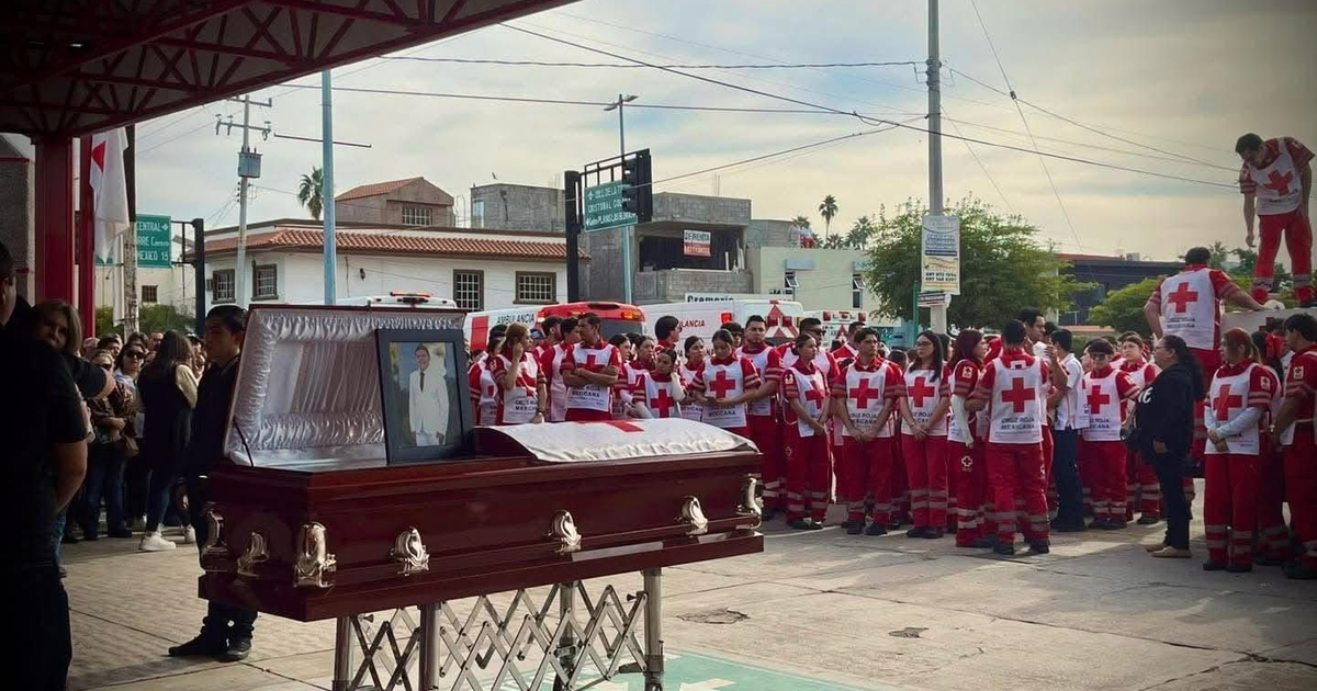 Funeral de José Alberto, paramédico de Cruz Roja, rodeado por compañeros y vehículos de emergencia.
