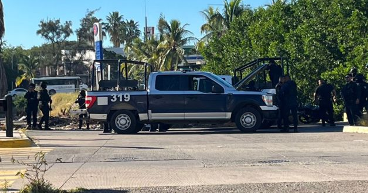 Agentes revisando camioneta policial con motor abierto en Mazatlán tras persecución.