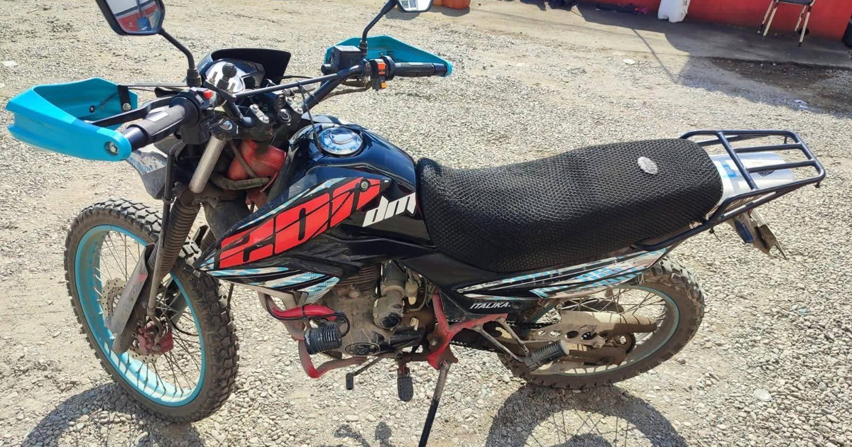 Motocicleta enduro negra con detalles azules y rojos sobre terreno de grava en Mazatlán, recuperada tras reporte de robo.