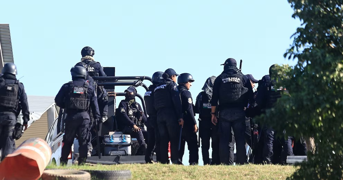 Policías en vestimenta táctica reunidos al aire libre en operación de seguridad en México.