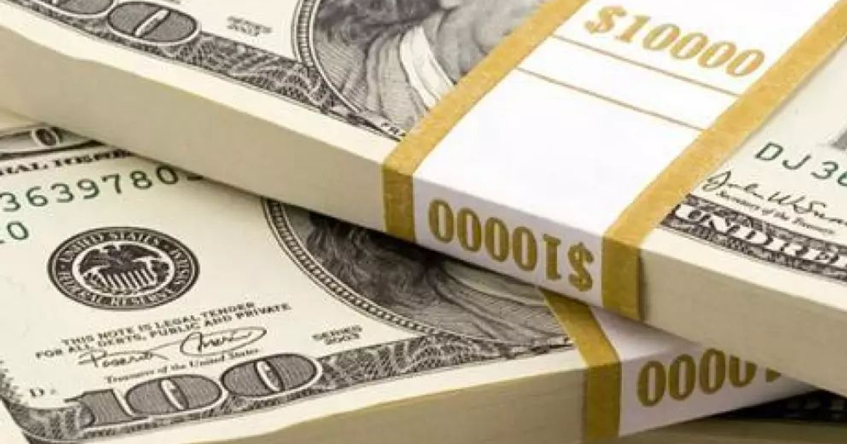 Paquetes de billetes de dólar estadounidense ordenados con bandas de papel mostrando $10,000