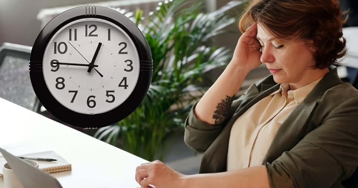 Mujer estresada en oficina con reloj de pared presente