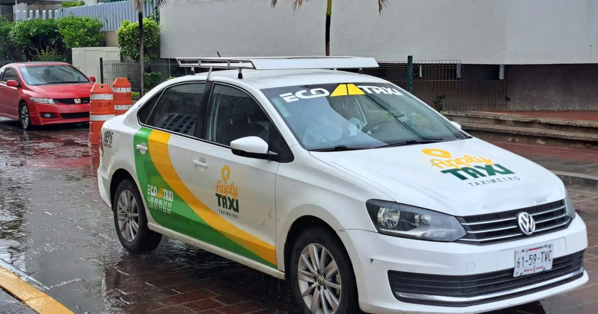 Taxi de Eco Taxis blanco con detalles verdes y amarillos estacionado en calle mojada junto a coche rojo, relacionados con robos en Mazatlán.