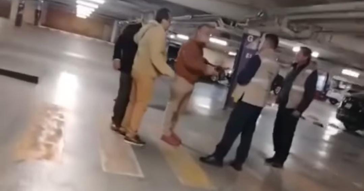 Diputado y personas discutiendo en estacionamiento cubierto de Town Square Metepec