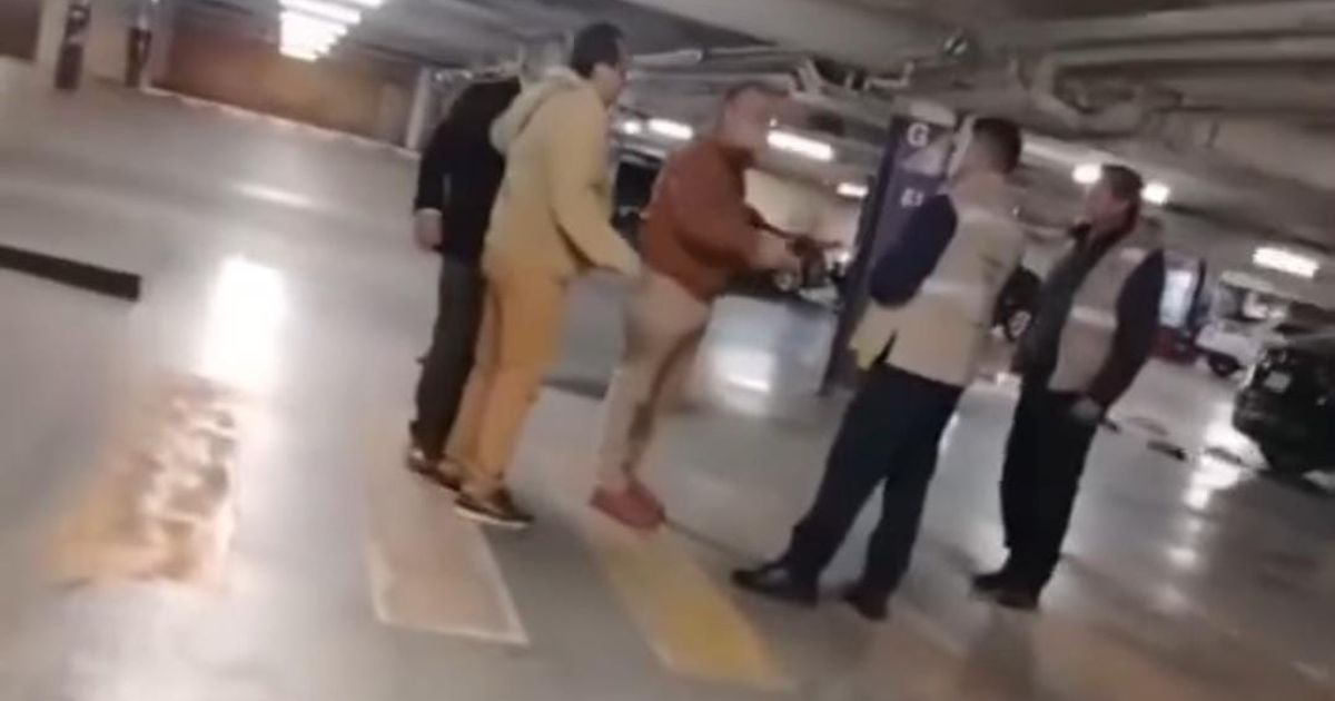 Grupo de personas discutiendo en un estacionamiento de Town Square Metepec