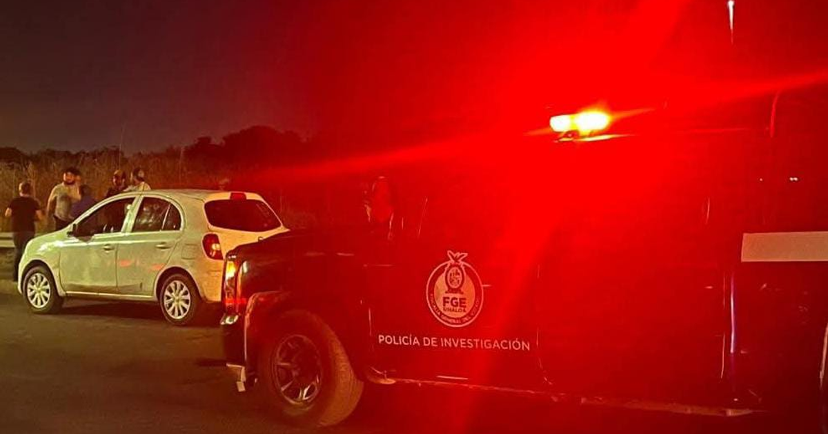 Escena nocturna de accidente con patrulla y auto blanco cerca de un camino rural