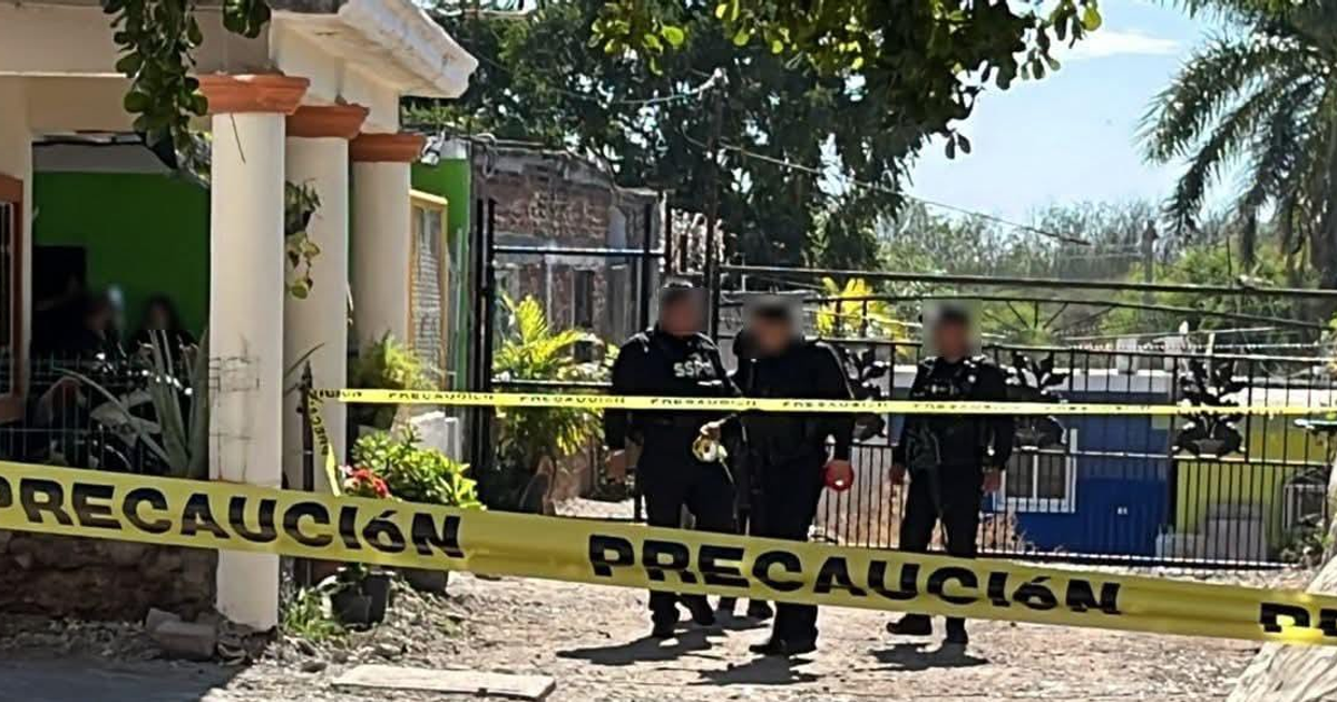 Policía en escena de crimen con cinta amarilla en Bellavista, Culiacán, una casa verde al fondo sugiere una investigación en curso
