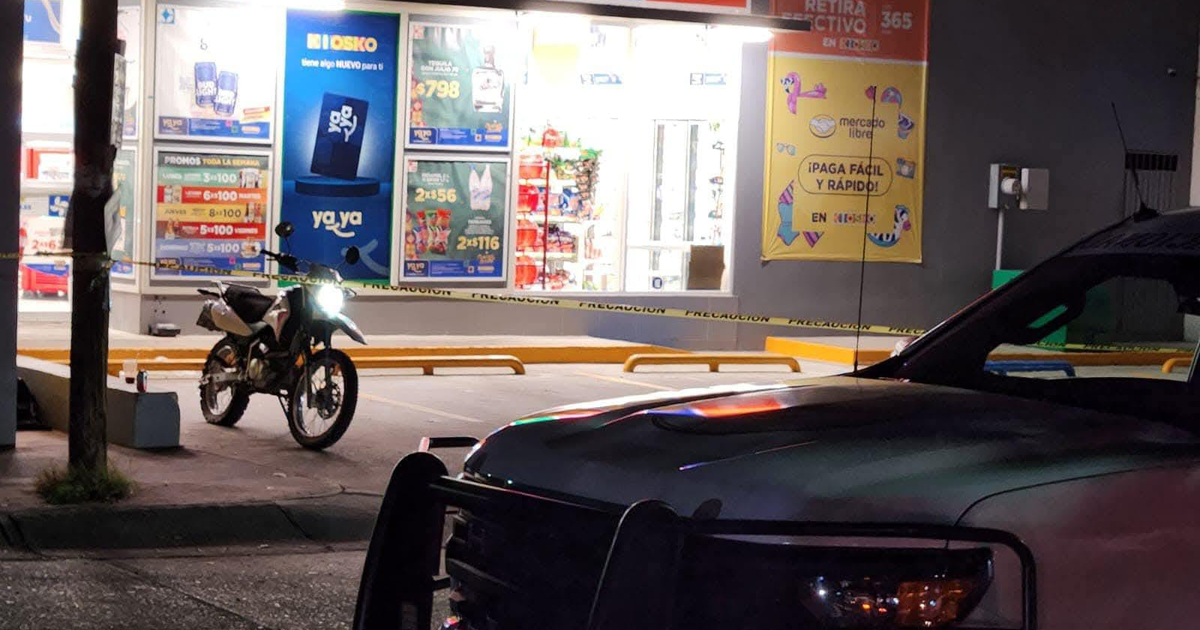 Zona comercial en Culiacán asegurada tras ataque armado nocturno, con motocicleta y vehículo policial presentes.