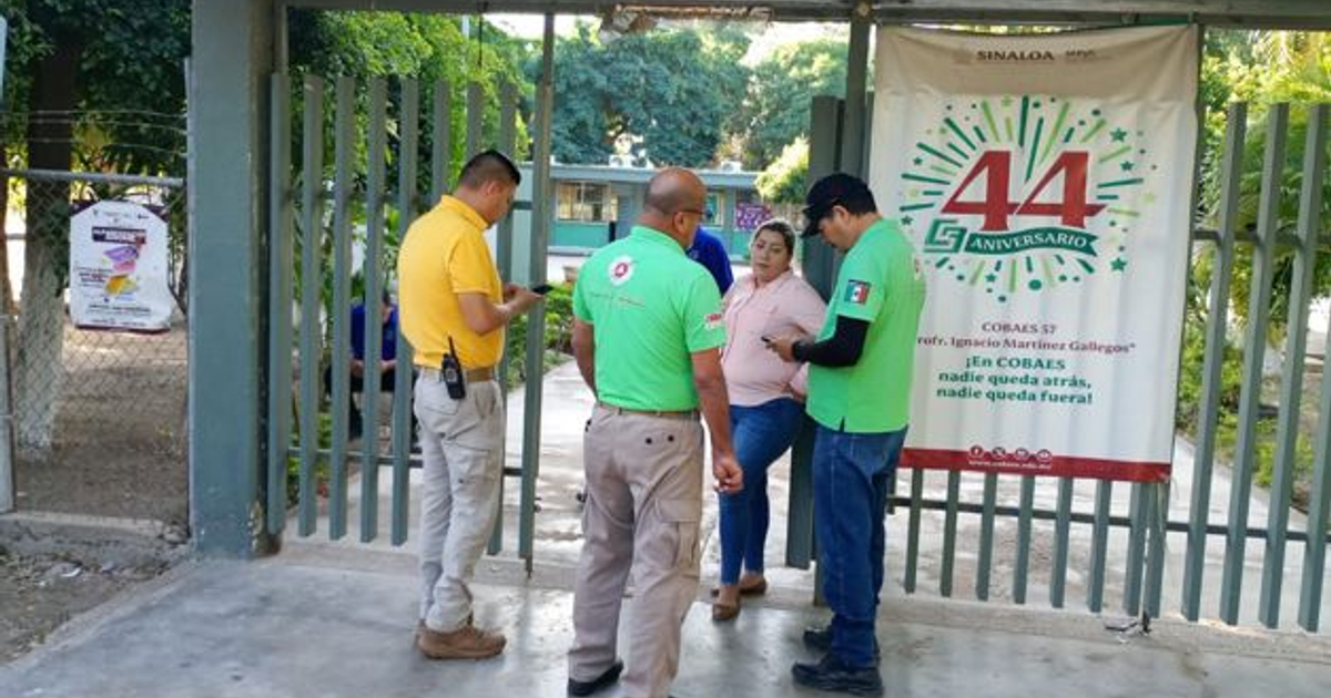 Personas frente al COBAES 57 con pancarta del 44 aniversario en medio de la evacuación por fuga de amoniaco.