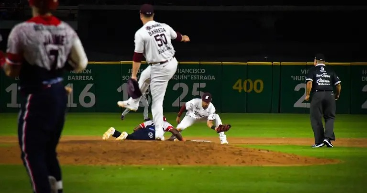 Partido de béisbol entre Águilas de Mexicali y Tomateros de Culiacán, mostrando jugadores en acción y un árbitro evaluando.