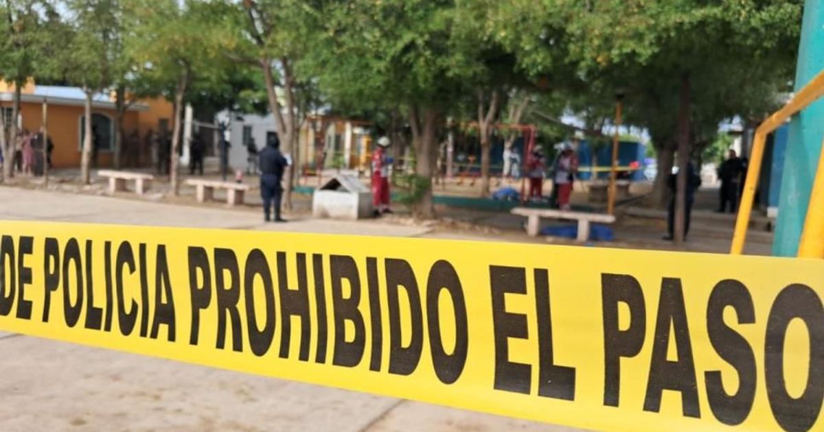 Cinta amarilla de policía 'PROHIBIDO EL PASO' en un parque, relacionada con el incremento de homicidios en Sinaloa 2025.