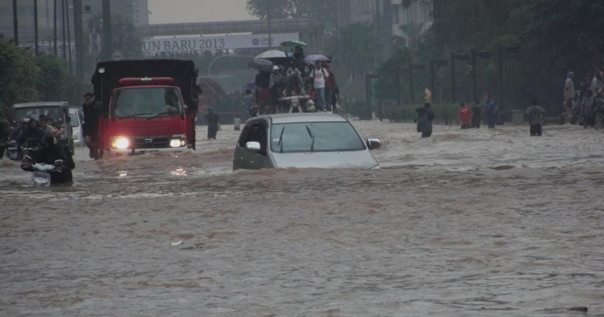 Inundaciones asiáticas: Vehículos y personas en calles anegadas tras intensas lluvias.