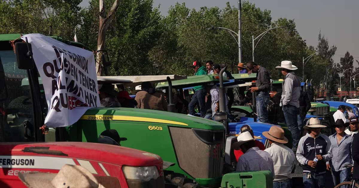 Manifestantes sobre tractores sosteniendo pancarta en protesta por Ley General de Aguas en México.