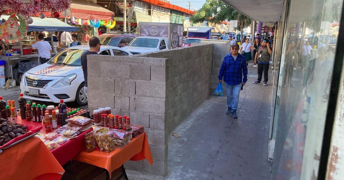 Calle Leandro Valle con mercado y muros de bloque limitando el paso peatonal