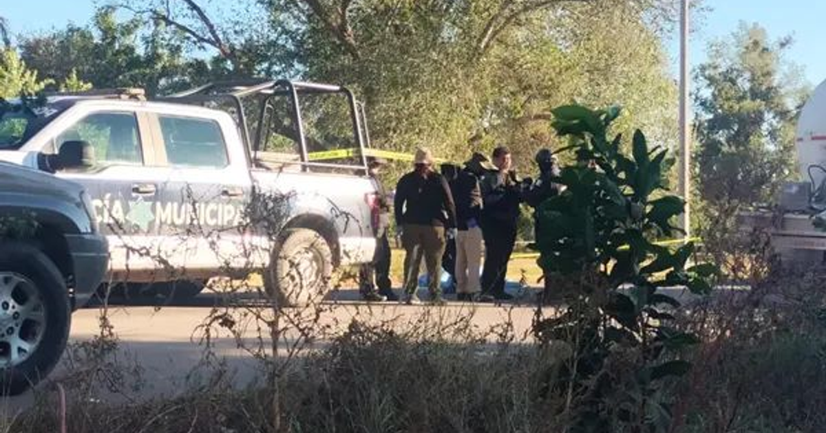 Vehículo policial y oficiales en escena investigativa en Navolato, Sinaloa.