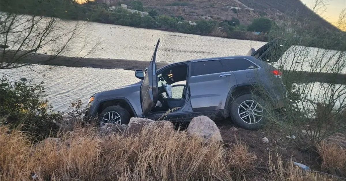 SUV gris accidentado cerca de un cuerpo de agua en los Mochis-Topolobampo
