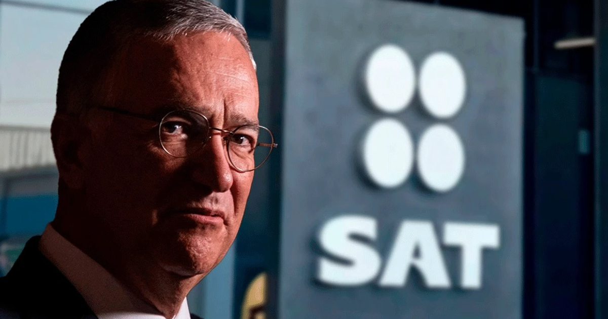 Hombre de mediana edad con gafas frente a un letrero del SAT en ambiente profesional
