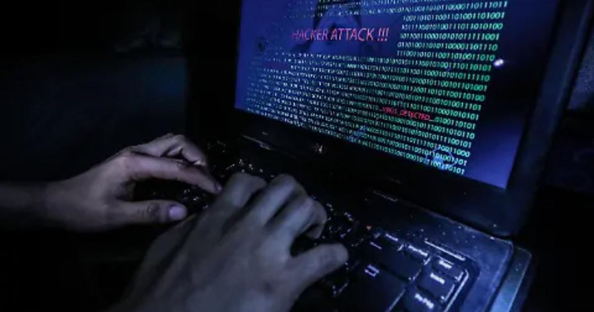 Manos en teclado con alerta de ataque cibernético.