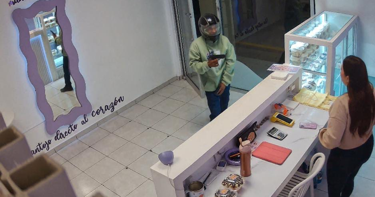 Asalto en el negocio de Kareli en Culiacán, donde un asaltante con casco amenaza con un arma a una mujer en el mostrador.