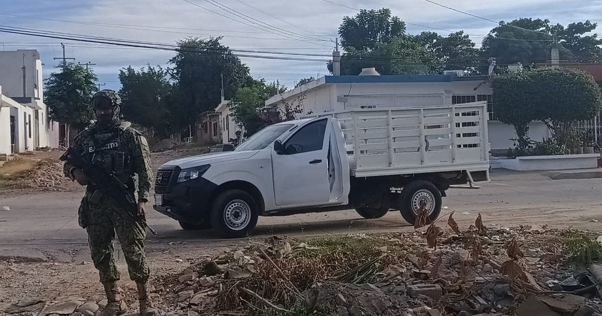 Soldado armado en Culiacán resguarda una camioneta durante operativo militar tras reportes de disparos.