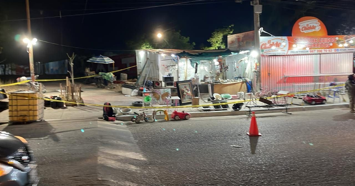 Zona comercial nocturna con tienda y valla de seguridad en Culiacán, Sinaloa.