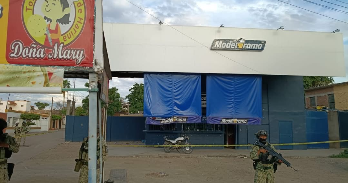 Imagen de un establecimiento Modelorama con cortinas azules y soldados armados cerca, en Culiacán.