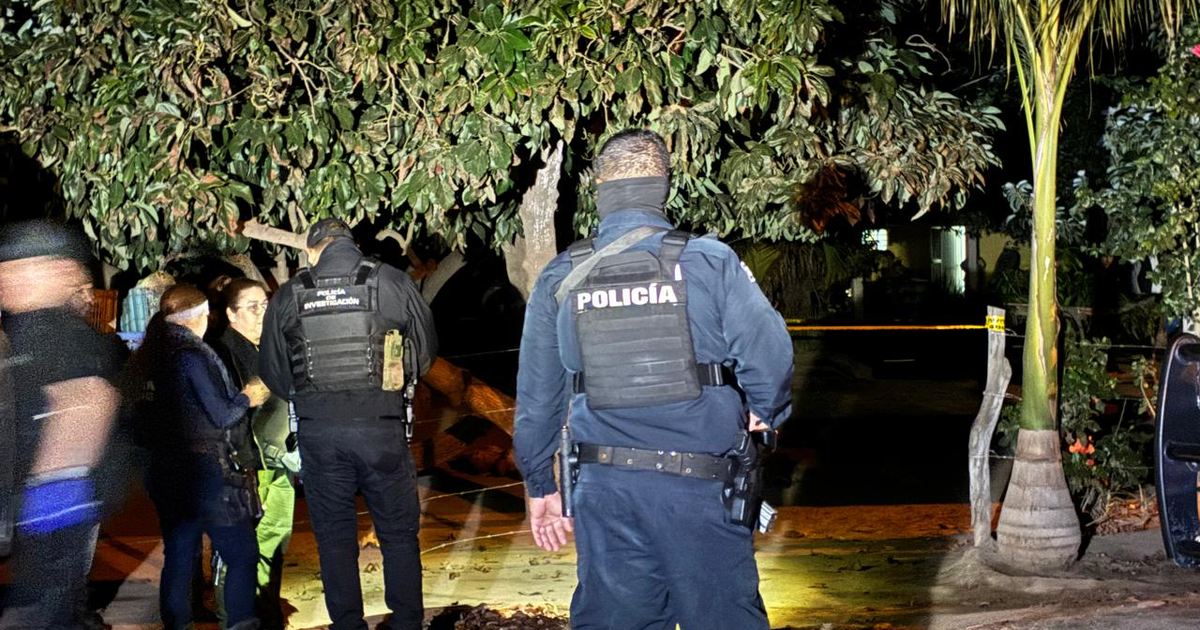 Policías investigando escena del crimen nocturna en El Limoncito.