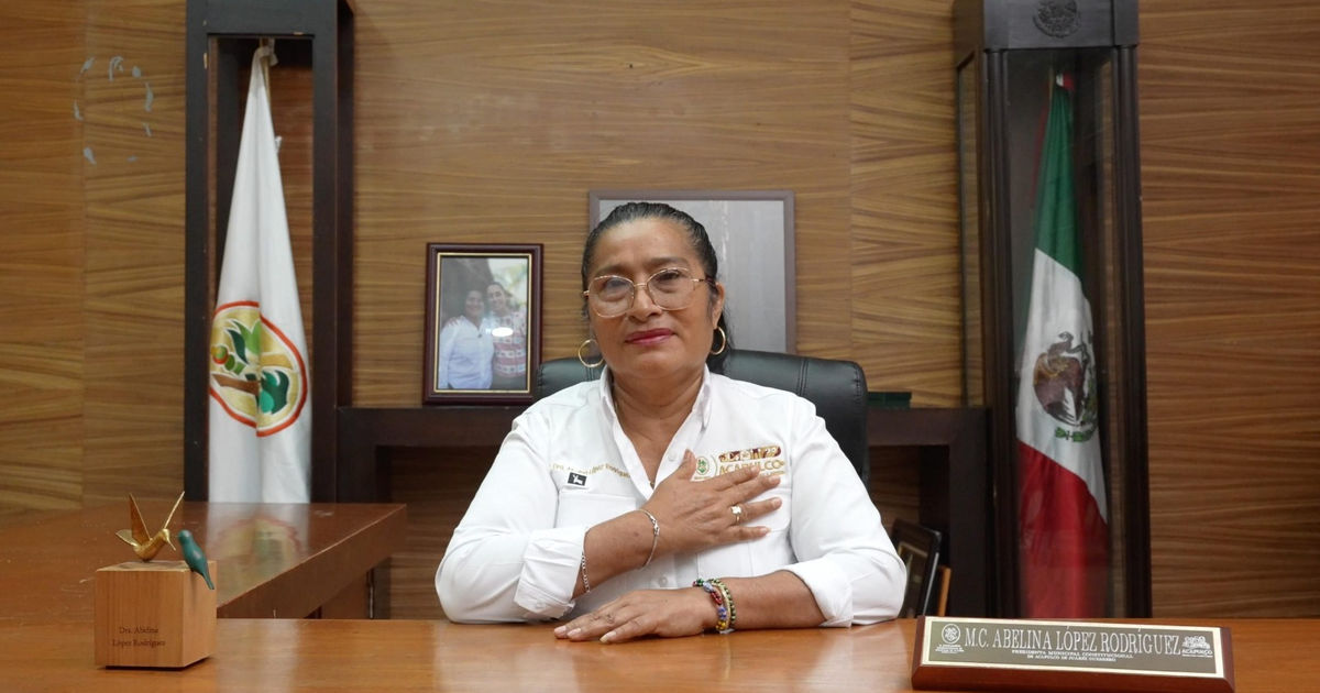 Abelina López Rodríguez en su oficina con una bandera de fondo tras el fallo favorable de la Suprema Corte