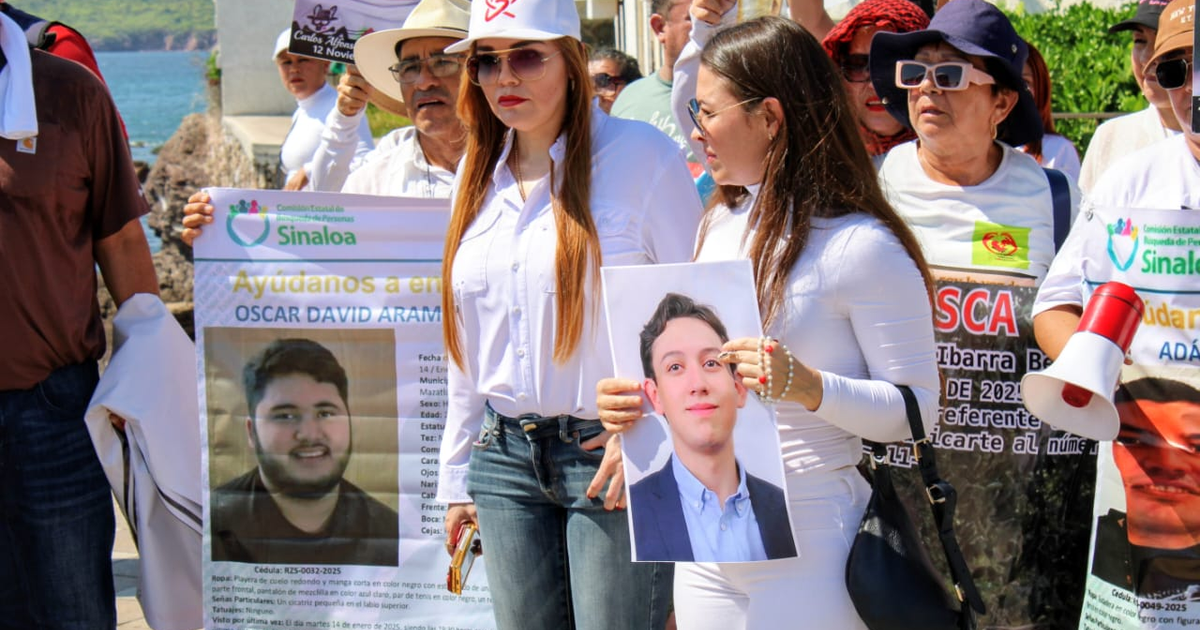 Grupo en vigilia sosteniendo fotos y carteles relacionados a la desaparición de Oscar David Arámbula.