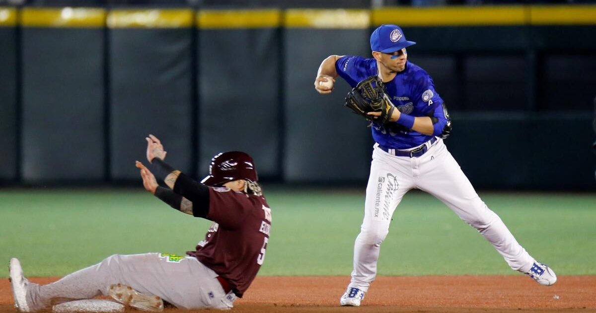 Jugador de béisbol deslizándose y otro lanzando durante el partido Charros vs Tomateros