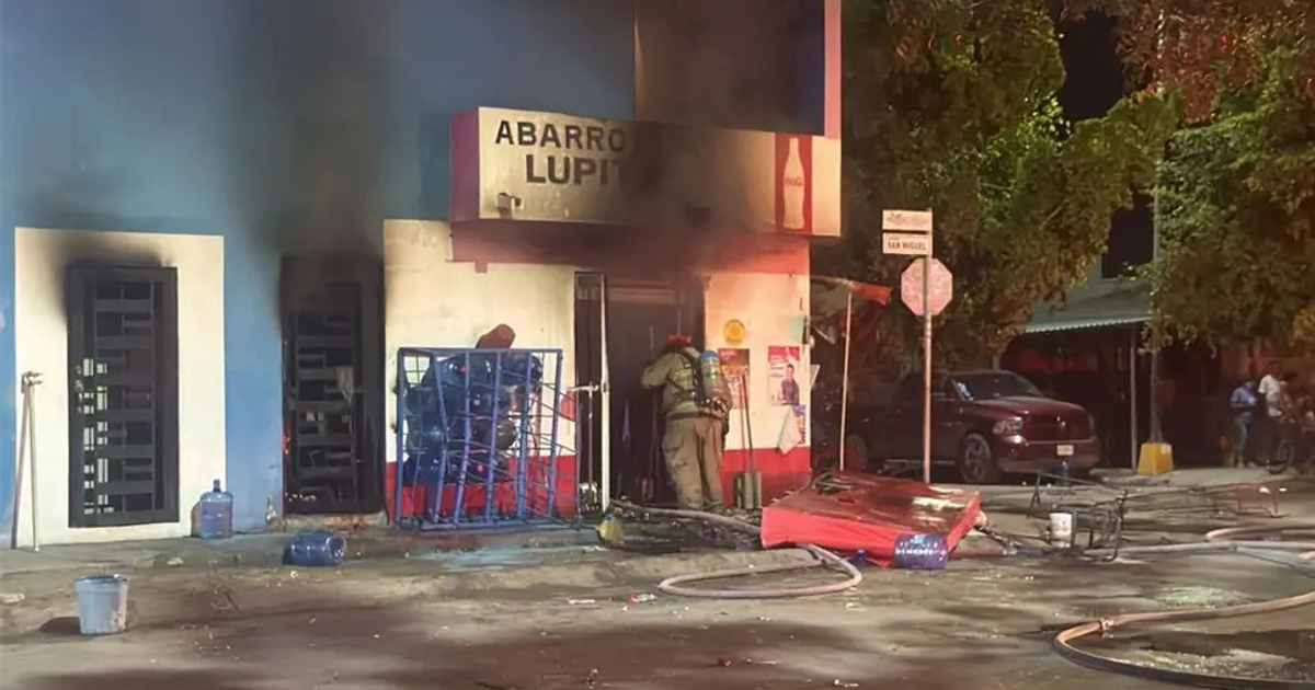 Bombero combatiendo incendio en Abarrotes Lupit de Mazatlán durante la noche