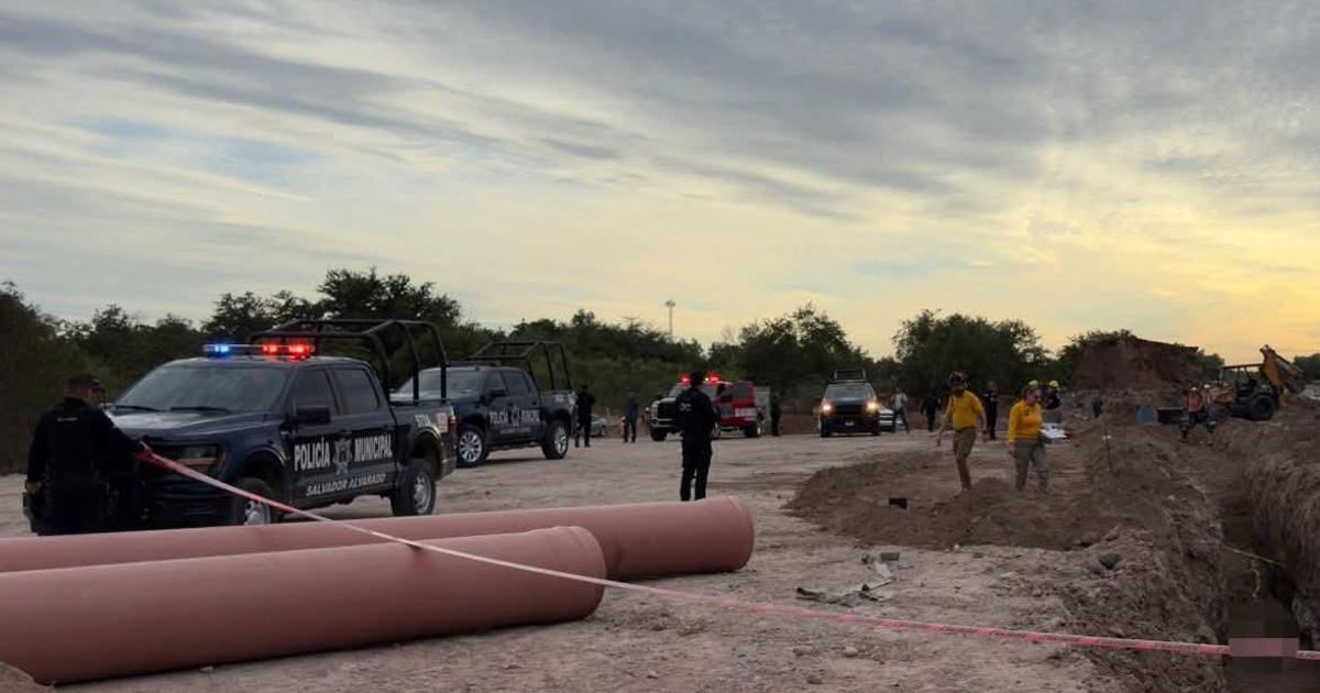 Camionetas de la Policía Municipal con luces encendidas y personal en área de excavación en Guamúchil.