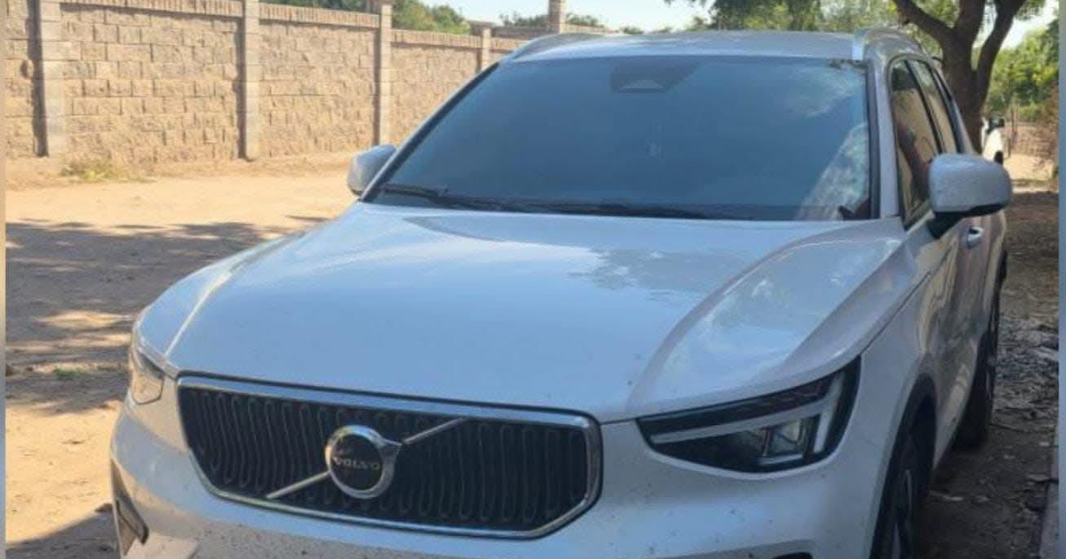 SUV blanco moderno cubierto de polvo en área con tierra y fondo de piedra en Navolatillo, Sinaloa.