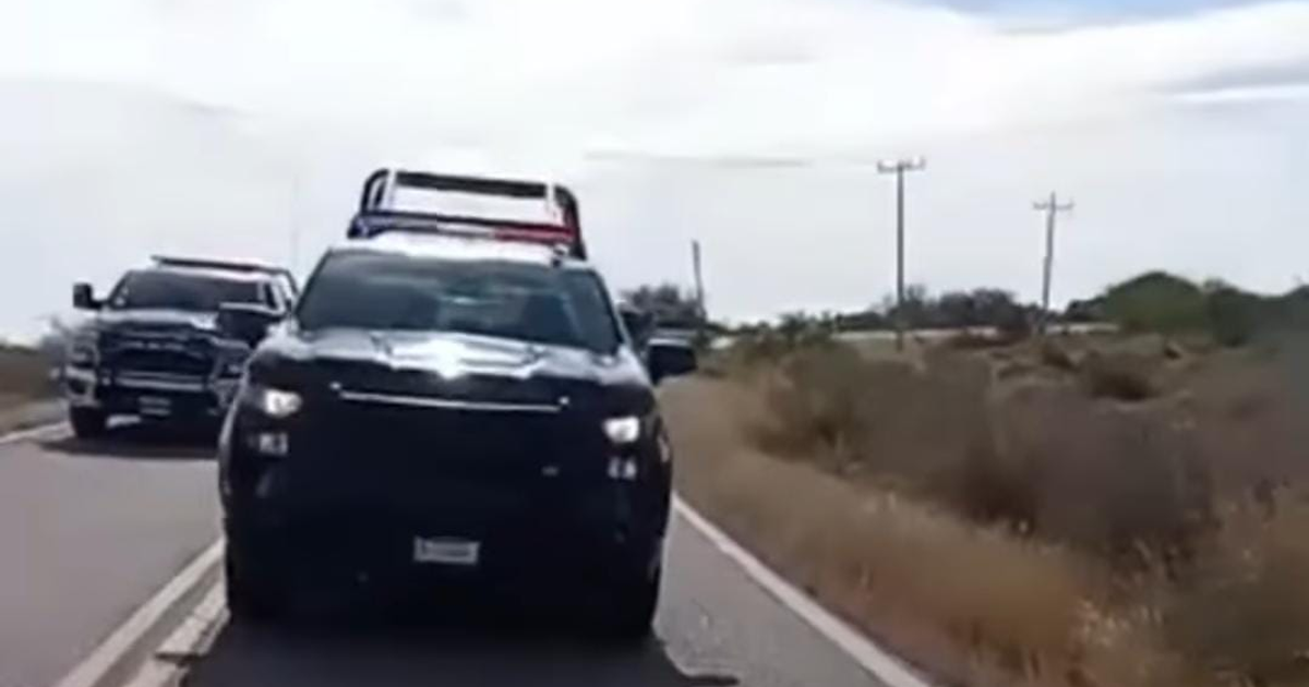 Carretera rural en Sinaloa con patrullas detenidas.