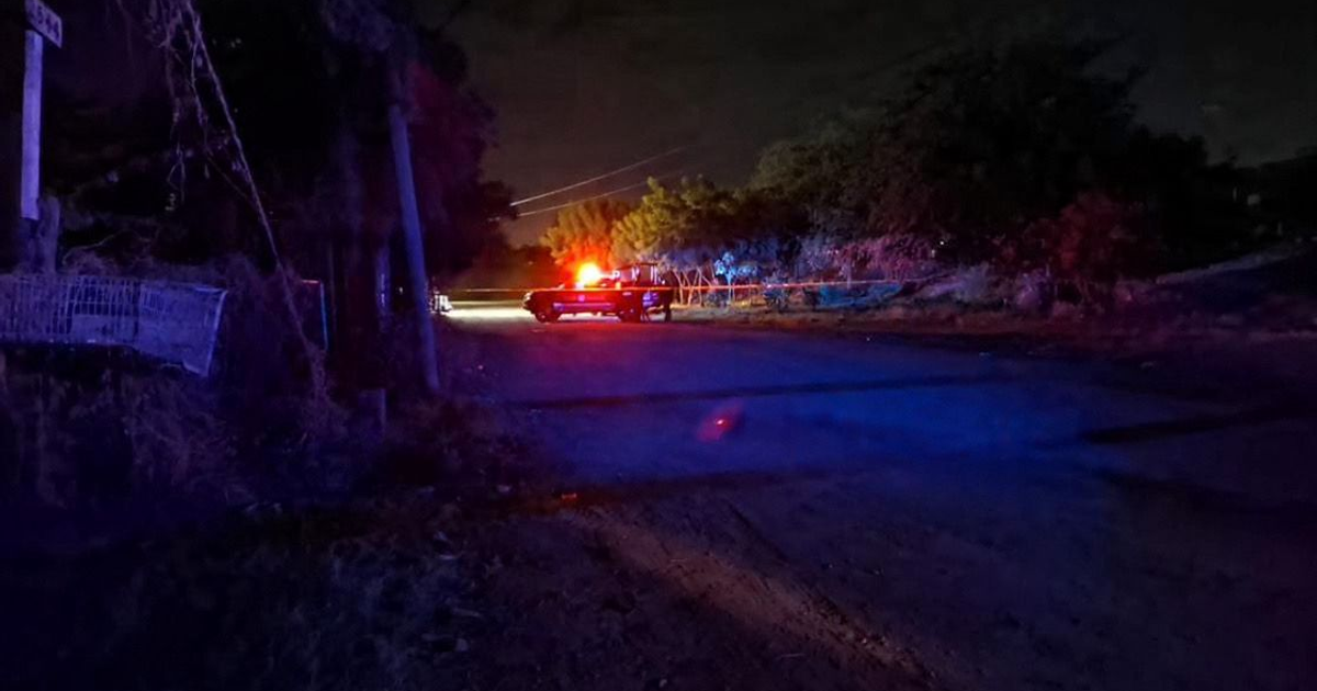 Vehículo con luces de emergencia en una calle oscura de Culiacán relacionada con un crimen.