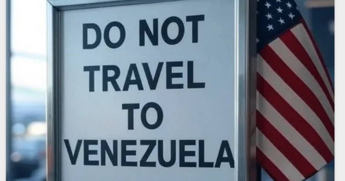 Cartel que dice 'DO NOT TRAVEL TO VENEZUELA' junto a bandera de EE. UU., advirtiendo sobre los riesgos de viajar a Venezuela debido a las amenazas de seguridad.