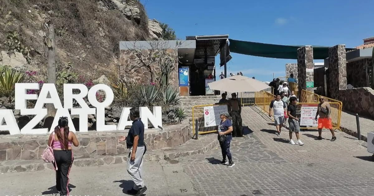 Entrada al Faro Mazatlán con visitantes y letrero principal bajo un cielo despejado.
