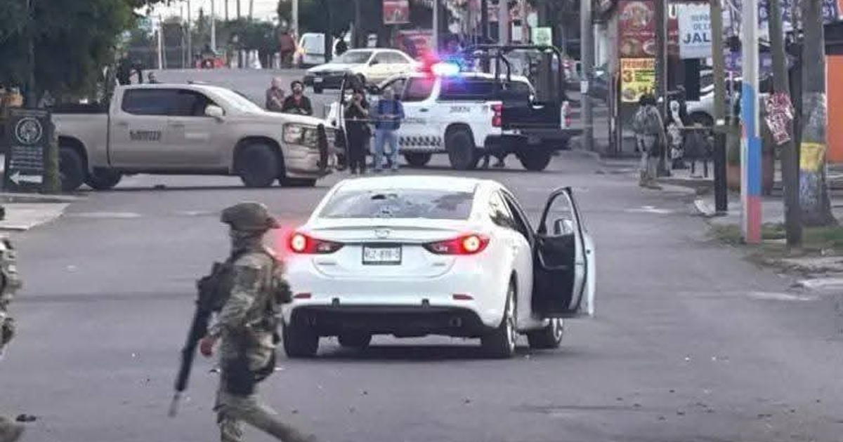 Escena urbana de seguridad con camioneta beige, auto blanco y personas en uniforme en Culiacán, Sinaloa.