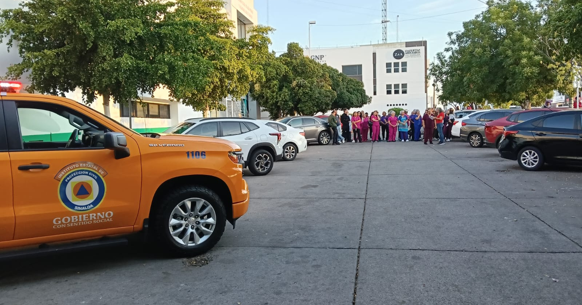 Estacionamiento con vehículos oficiales y personal de emergencia tras evacuación por olor a gas en Culiacán.