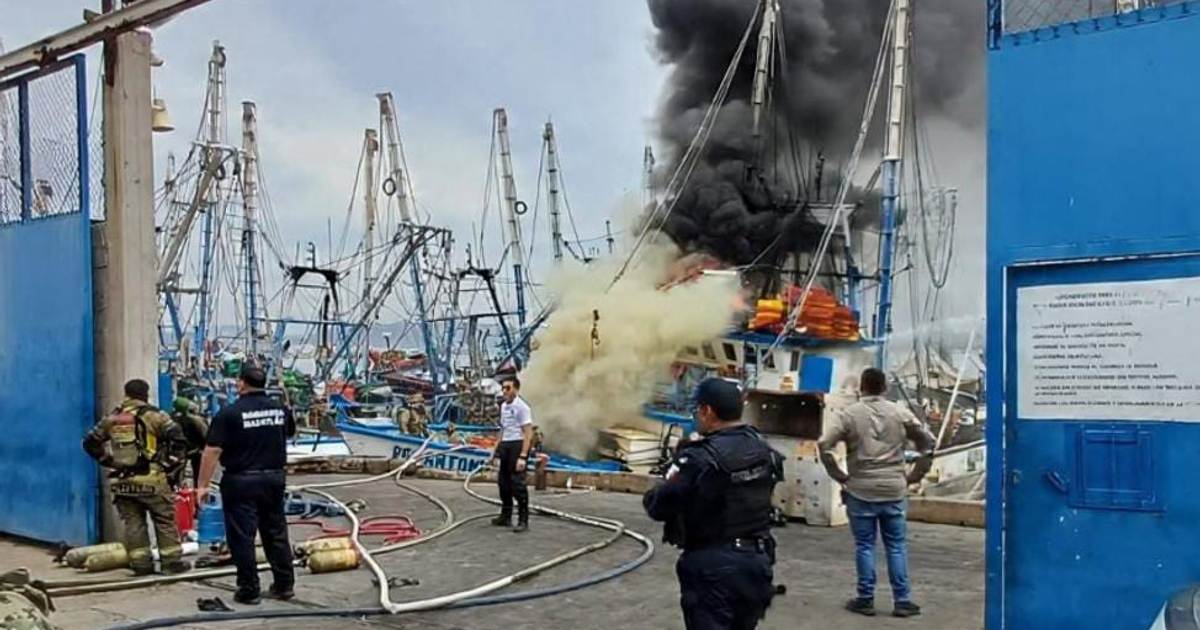 Escena de puerto con incendio en el barco camaronero Don Antonio Pérez III en Mazatlán, con bomberos y policías respondiendo a la emergencia.