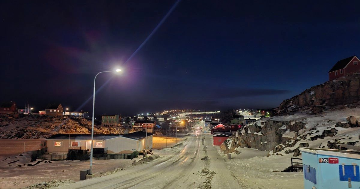 Nocturne in Nuuk: Snow-covered colored houses under starry sky signify peaceful, resistant Greenland.