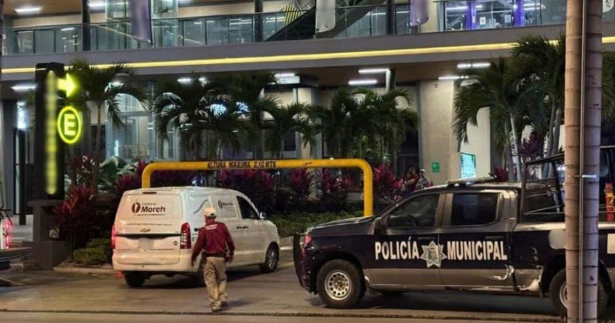 Escena urbana en Mazatlán con edificio moderno, vehículo de carga y policía municipal