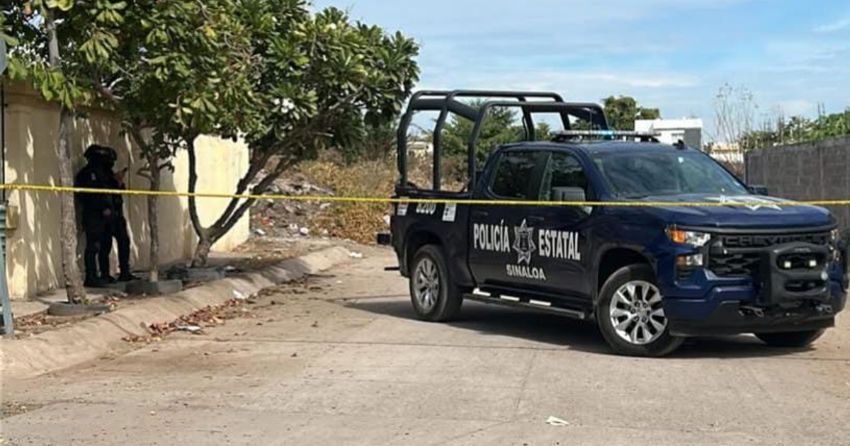 Vehículo de la Policía Estatal frente a pared con agentes y cinta amarilla en escena de crimen en Culiacán